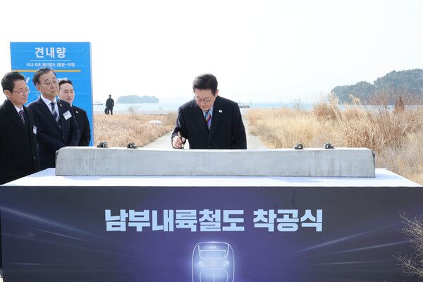 이재명 대통령이 6일 경남 거제시 견내량 인근에서 열린 남부내륙철도 착공식에서 침목에 서명하고 있다. [연합뉴스]