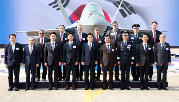 이재명 대통령이 25일 경남 사천 한국항공우주산업(KAI)에서 열린 KF-21 양산 1호기 출고식에서 참석자들과 기념촬영을 하고 있다. [연합뉴스]