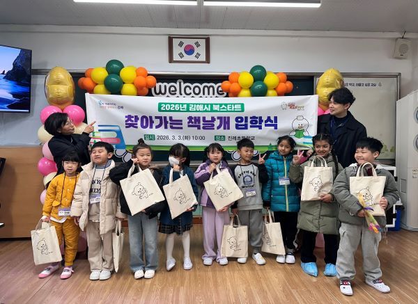 진례초등학교 신입생들이 ‘찾아가는 책날개 입학식’에서 북스타트 책꾸러미를 들고 기념촬영을 하고 있다. [김해시]