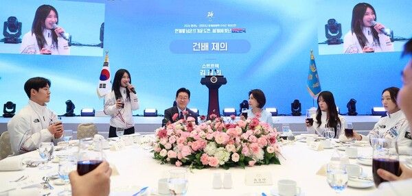쇼트트랙 국가대표 김길리가 5일 청와대 영빈관에서 이재명 대통령이 마련한 2026 밀라노-코르티나담페초 동계올림픽 선수단 격려 오찬에서 건배제의를 하고 있다. 왼쪽부터 스켈레톤 정승기, 김길리, 이재명 대통령, 김혜경 여사, 스노보드 최가온, 쇼트트랙 최민정. [연합뉴스]