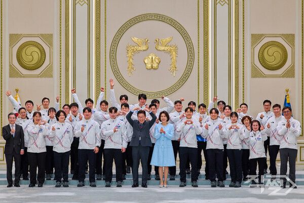이재명 대통령과 김혜경 여사가 5일 청와대 영빈관에서 열린 2026 밀라노-코르티나담페초 동계올림픽 선수단 격려 오찬을 마친 뒤 선수단과 함께 기념촬영을 하고 있다. [청와대]