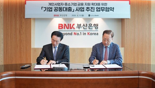 김성주 BNK부산은행장(왼쪽)과 윤호영 카카오뱅크 대표이사가 지난 13일 부산은행 본점에서열린 기업 공동대출 사업 추진 업무협약을 체결하고 있다. [BNK부산은행]