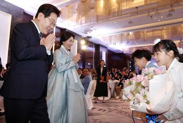 베트남을 국빈 방문 중인 이재명 대통령과 김혜경 여사가 22일(현지시간) 하노이의 한 호텔에서 열린 동포간담회에서 화동과 인사하고 있다. [연합뉴스]