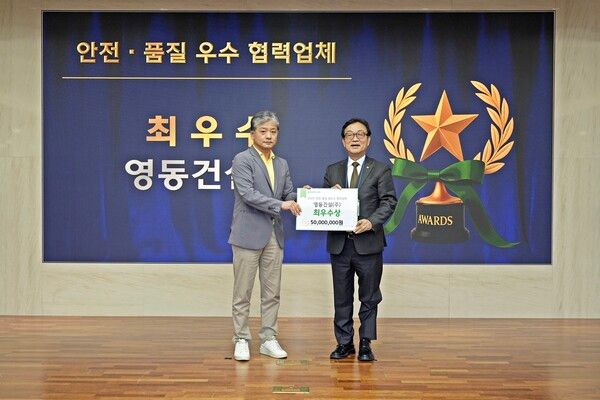 현대엔지니어링이 개최한 ‘안전·품질 우수 협력업체 시상식’에서 주우정 현대엔지니어링 대표이사(왼쪽)가 최우수상 수상 협력업체인 이재환 영동건설 대표에게 포상금을 전달하고 있다. [현대엔지니어링]