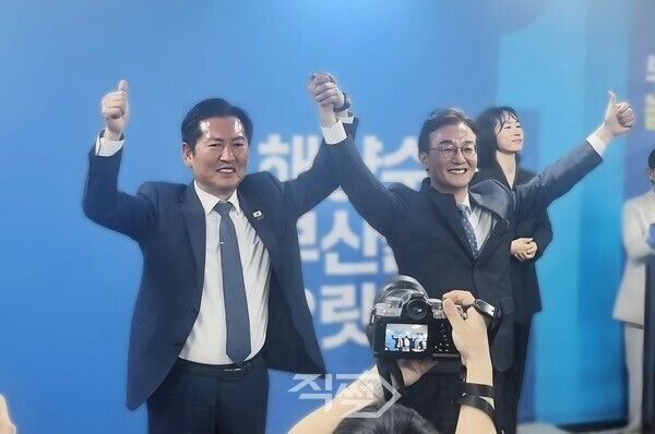 더불어민주당 정청래 당대표와 전재수 부산시장 후보가 부산진구 선거사무소 개소식에서 손을 맞잡은 채 기념촬영을 하고 있다. [박정우 기자]