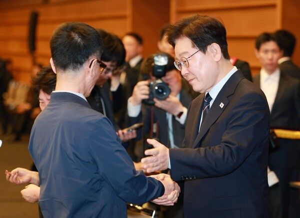 이재명 대통령이 8일 서울 중구 대한상공회의소에서 열린 어버이날 기념식에서 순직 소방관, 경찰관 부모님들에게 카네이션을 달아드린 후 한 유가족을 위로하고 있다. [연합뉴스]