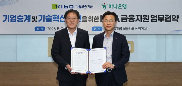 협약식에 참석한 서유석 하나은행 기업그룹 부행장(사진 오른쪽)이 이상창 기술보증기금 이사(사진 왼쪽)와 함께 협약서를 들고 기념촬영을 하고 있다. [하나은행]