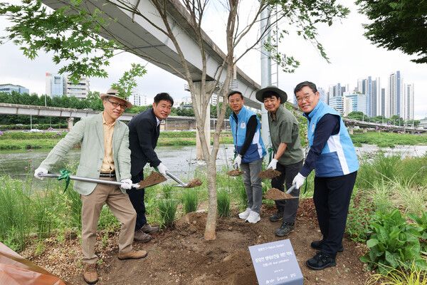 고광현 성동구 부구청장(왼쪽에서 두 번째), 김보현 대우건설 대표이사(오른쪽에서 첫 번째)를 포함한 참석자들이 단풍나무 식수 활동을 진행하고 있다. [대우건설]