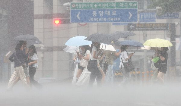 17일 대구 중구 동성로에서 시민들이 우산을 쓰고 쏟아지는 장맛비를 피하며 이동하고 있다. [연합뉴스]