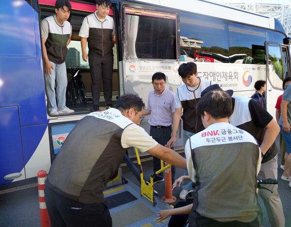 BNK경남은행 사회공헌홍보부 직원들이&nbsp;27일 오전 마산종합운동장에서 야영대회로 떠나는 장애인들의 버스 탑승을 돕고 있다. [BNK경남은행]
