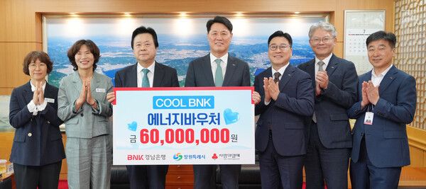 김태한 BNK경남은행 은행장(사진 오른쪽 네번째)이 창원시 강기윤 시장에게 ‘6000만원 상당의 에너지바우처’를 전달하고 있다. [BNK경남은행]