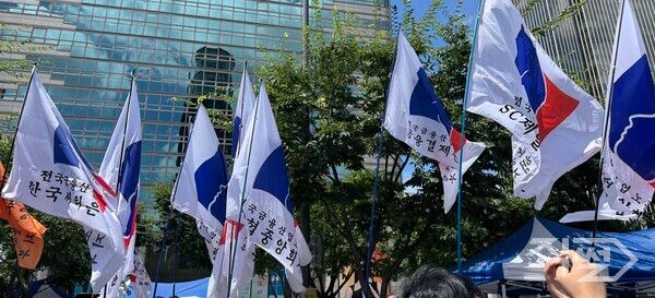 지난달 29일 서울 광화문 동화면세점 앞에서 열린 농협 본사 강제이전 반대 집회 시위에 참가한 관련 노조 깃발들이 펄럭이고 있다. [손성은 기자]