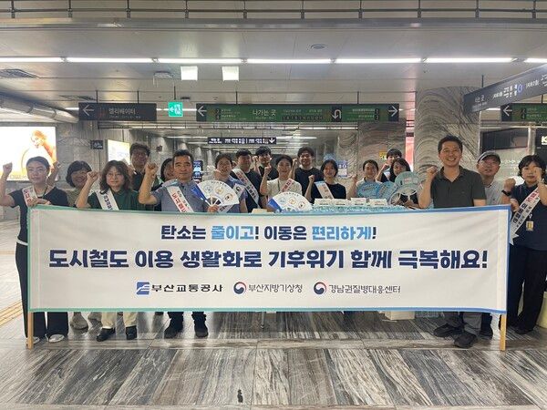 부산지방기상청과 부산교통공사, 경남권질병대응센터 관계자들이 부산도시철도 3호선 미남역에서 '폭염 엔 생수' 캠페인을 마친 뒤 기념촬영을 하고 있다. [부산지방기상청]