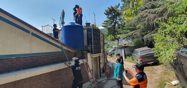 부산진소방서와 부산진구 관계자들이 공동우물이 고갈된 부암3동 고지대 주택 물탱크에 생활용수를 긴급 공급하고 있다. [진구]