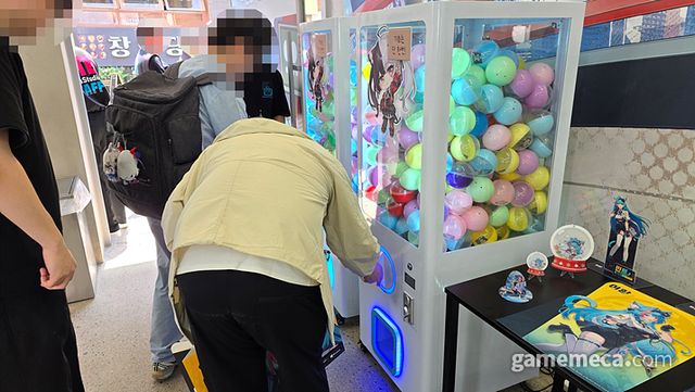 여러 작은 굿즈들이 있는 뽑기 기계를 직접 돌리면…