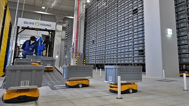 물류 작업자가 자율 이동 로봇에 상품을 담고 있다. /사진=CJ올리브영