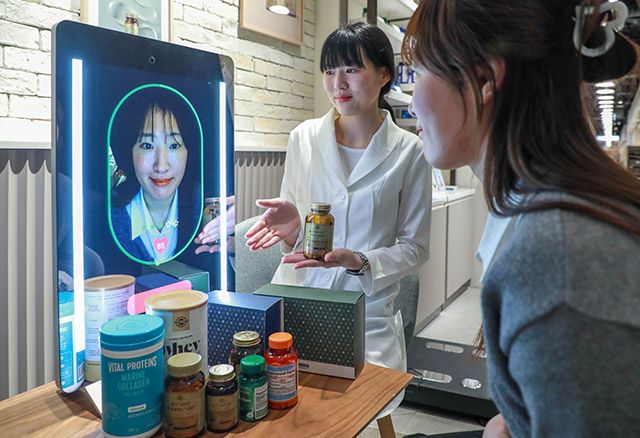 현대백화점 목동점에 네슬레 헬스사이언스 스토어에 설치된 AI 헬스케어 기기 ‘아누라 매직미러’를 고객이 체험하고 있다./사진=현대백화점그룹