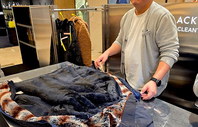 블랙라벨 관계자가 오염부위 등 세탁물을 꼼꼼하게 확인하며 세탁 작업 등을 설명해주고 있다./사진=김경희