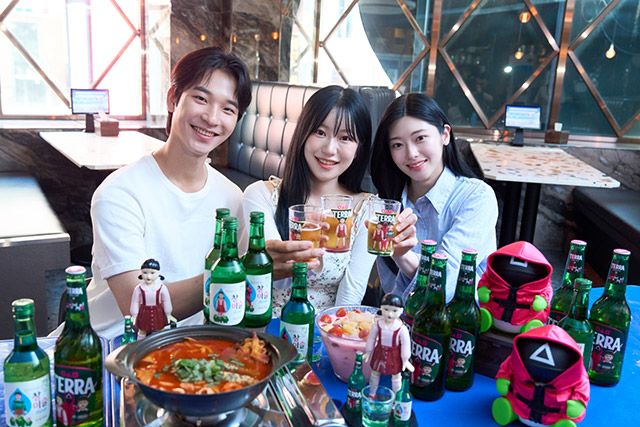 방학 시즌을 맞은 대학생들이 ‘테라·참이슬 오징어 게임 에디션’ 제품과 굿즈를 함께 즐기고 있다./사진=하이트진로