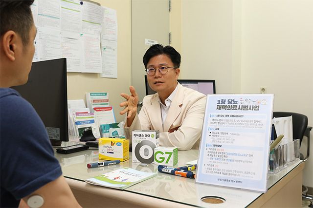 삼성서울병원 내분비대사내과 김재현 교수가 1형당뇨병 환자에게 연속혈당측정기에 대해 설명하고 있다. /사진 제공=삼성서울병원