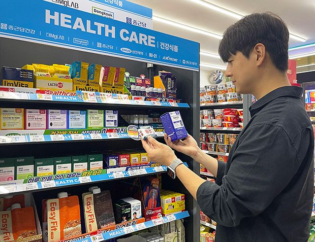 GS25에서 모델이 건강 카테고리 전문 매대 앞에서 상품을 살펴보고 있다./사진=GS25