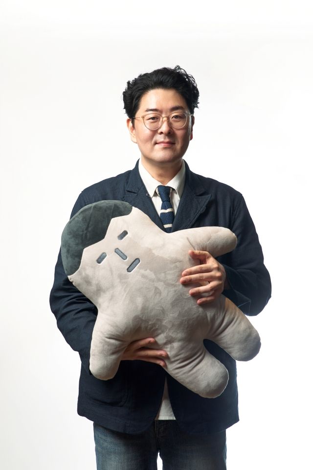 영화 '악마가 이사왔다'의 시나리오를 쓰고 연출한 이상근 감독이 작품 속 캐릭터 인형 '길군'을 들고 있다. / 사진 : CJ ENM