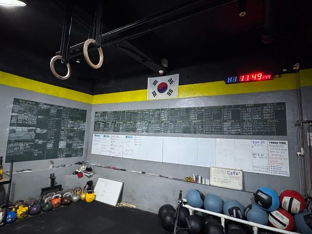 크로스핏 마하 박스 한 켠에 있는 칠판 모습. WOD를 기록하는 화이트보드와 시계가 있다./염도영 기자