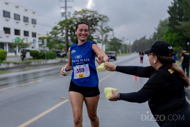 러너에게 물에 적신 스펀지를 건네는 지역 주민(사진제공=마리아나관광청)