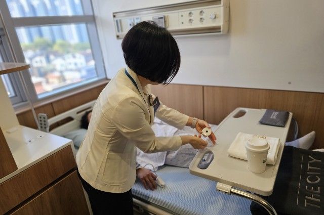 의료진이 환자에게 웨어러블 센서를 부착하는 과정을 시연하고 있다.