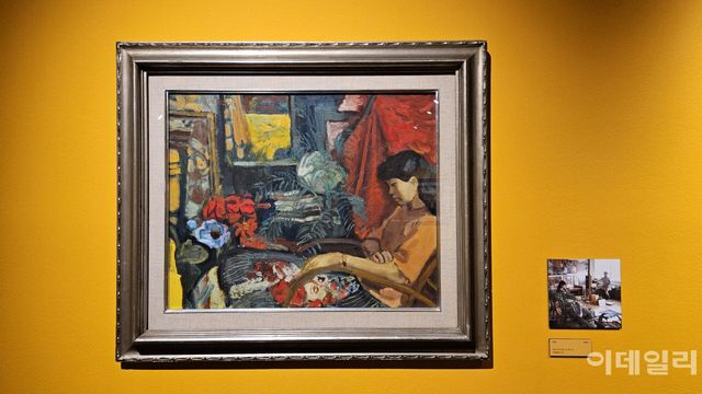 임직순의 ‘여인’(1985, 53×65㎝) 옆으로 모델을 앉혀두고 작업하는 화백을 포착한 사진이 붙었다. 그림은 사진 속 화백의 위치에서 바라보이는 모델의 모습과 일치한다(사진=오현주 문화전문기자).