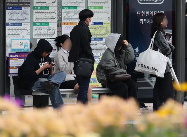 19일 가을비가 내린 뒤 '쌀쌀한 출근길'에 서울 세종로에서 시민들이 외투차림으로 버스를 기다리고 있다. (사진=뉴스1)
