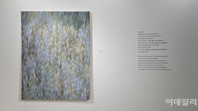 우병윤의 선화랑 개인전 ‘중첩: 들떠 있는 풍경’ 전경. 작품 ‘중첩 26-01-299’(2026, 145.5×112.0㎝)와 함께 작업 중에 떠올렸을 작가의 단상을 옮겨놨다. “아이러니하게도 자연을 들여다보면 볼수록 우리가 볼 수 있는 건 우리밖에 없다는 걸 깨닫는다”고 썼다(사진=오현주 문화전문기자).