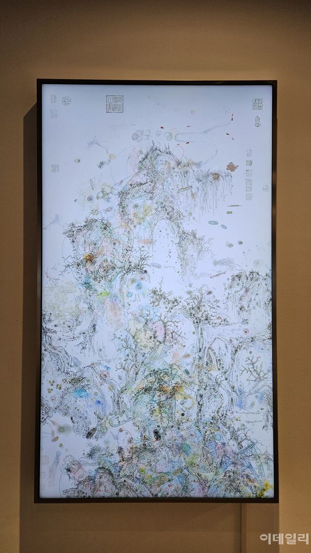 이이남의 ‘미시산수-조춘도 no.2’(2026, 170×97.9㎝). 중국 북송 때 화가 곽희의 ‘조춘도’ 위에 담양 용소폭포에서 건져낸 한 방울 물에서 현미경으로 들여다본 미생물의 세계를 얹어 완성한 미디어 작품이다. 9분 23초짜리 단채널 영상에서 미생물은 쉼없이 꿈틀댄다(사진=오현주 문화전문기자).