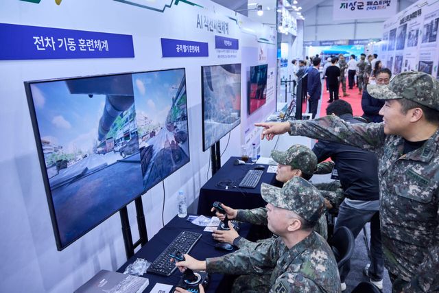 SKT 전시 부스를 찾은 군 관계자들이 ‘AI 참모(AI 작전 지원 체계)’를 체험하고 있는 모습.