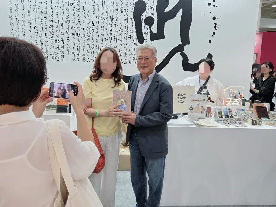 문재인 전 대통령이 ‘서울국제도서전’을 찾은 관람객과 기념촬영을 하고 있다(사진=이윤정 기자).
