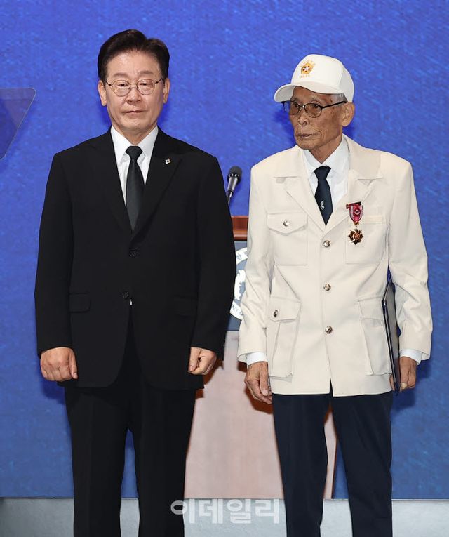 이재명 대통령이 25일 경기 수원시 영통구 수원컨벤션센터에서 열린 6·25 전쟁 제76주년 기념식에서 미8240부대 올팩4부대에 입대해 북한군 귀순 유도 작전, 적 후방 교란 등을 실시한 이영복 씨에게 화랑무공훈장을 수여한 뒤 기념촬영을 하고 있다.(사진=뉴스1)