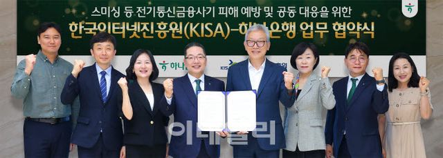 하나은행은 지난 25일 오후 서울 중구 을지로 본점에서 한국인터넷진흥원(KISA)과 ‘스미싱 등 전기통신금융사기 피해 예방 및 공동 대응을 위한 업무협약(MOU)’을 체결했다. 이날 협약식에 참석한 이호성 하나은행장(왼쪽에서 네번째)과 이상중 한국인터넷진흥원장(왼쪽에서 다섯번째)이 업무협약식을 마치고 양 기관의 주요 관계자들과 함께 기념촬영을 하고 있다.(사진=하나은행 제공)
