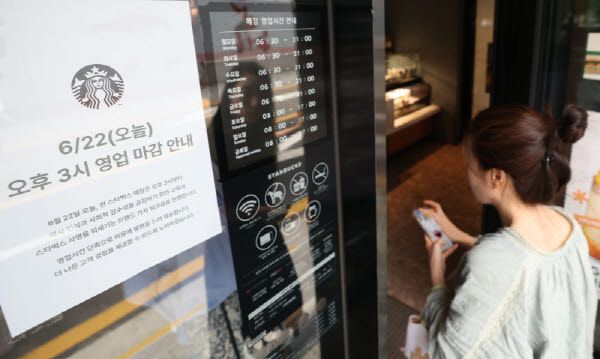 ‘탱크데이’ 마케팅 논란에 스타벅스 코리아가 국내 진출 이후 최초로 모든 매장의 영업을 조기 종료하는 22일 서울 한 스타벅스 매장 앞에서 한 시민이 영업시간 변경 안내문을 바라보고 있다.(사진=이데일리 이영훈 기자)