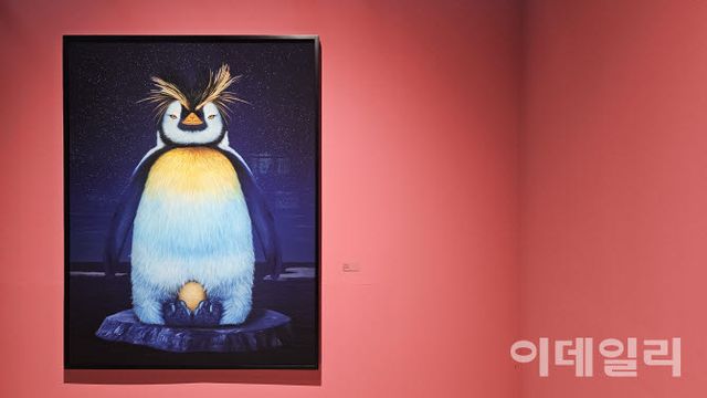 고상우 개인전 ‘너와 함께 쉬는 숨’ 전경. 작가의 작품 ‘마카로니’(Macaroni, 2026, 162×122㎝)가 걸렸다. 알을 품고 있는 황제펭귄이다. 짙은 어둠 속에 별빛이 총총한 시공간은 작가가 즐겨 쓰는 배경이다(사진=오현주 문화전문기자).