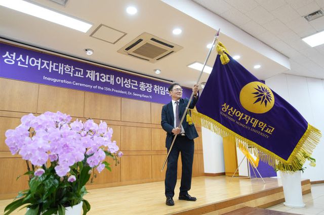 제13대 총장 취임식에서 학교기를 전달받은 이성근 총장이 힘차게 교기를 흔들고 있다.(사진=성신여대)