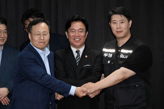 5월 20일 경기도 수원시 장안구 경기고용노동청에서 열린 삼성전자 임금협상을 마친 후 여명구 삼성전자 DS(디바이스솔루션·반도체 사업 담당) 피플팀장과 최승호 삼성그룹 초기업노동조합 삼성전자지부 위원장이 잠정 합의안에 서명한 후 김영훈 고용노동부 장관과 기념촬영을 하고 있다.(사진=공동취재)