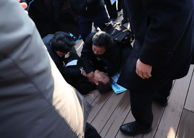 지난 2024년 1월 당시 이재명 더불어민주당 대표가 부산 가덕도 신공항 부지를 둘러본 후 기자들과 문답을 진행하던 중 왼쪽 목 부위에 습격을 당해 피를 흘린 채 쓰러져 있다. (사진=연합뉴스)