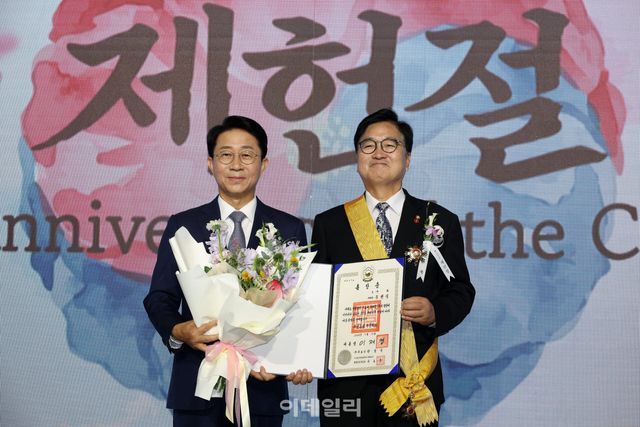 [국회사진기자단] 조정식 국회의장이 17일 서울 여의도 국회에서 열린 제78회 제헌철 경축식에서 우원식 전 국회의장에게 무궁화장을 전수한 뒤 기념 촬영을 하고 있다.