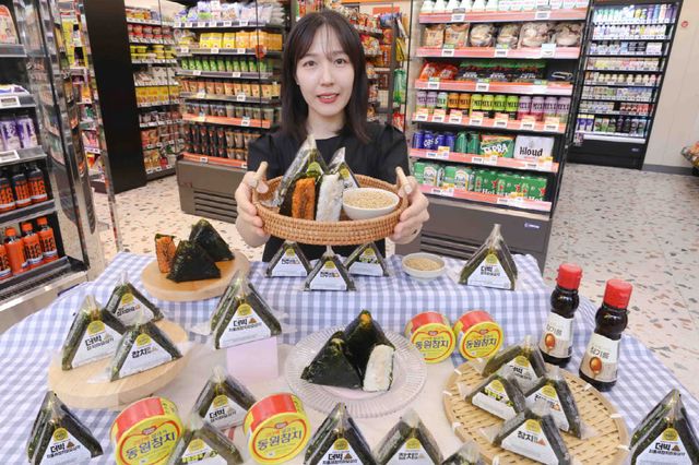 모델이 이마트24 매장에서 리뉴얼한 삼각김밥 제품들을 소개하고 있다. (사진=이마트24)