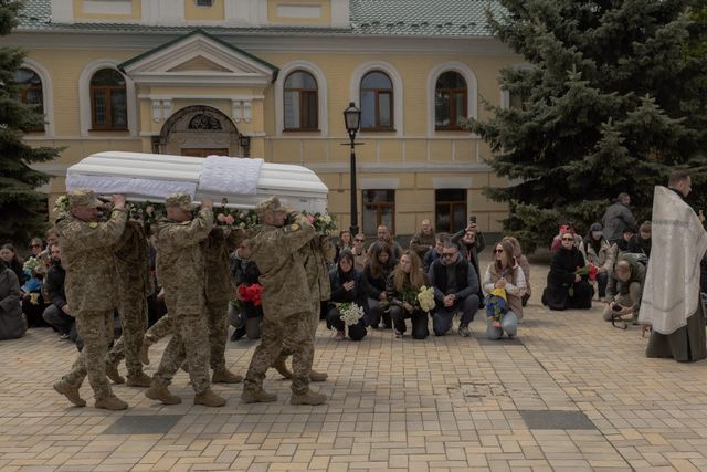 지난 4월 우크라이나 키이우의 성 미하일 수도원에서 열린 한 우크라이나 군인의 장례식에서 조문객들이 무릎을 꿇은 채 애도하고 있다. (사진=AFP)