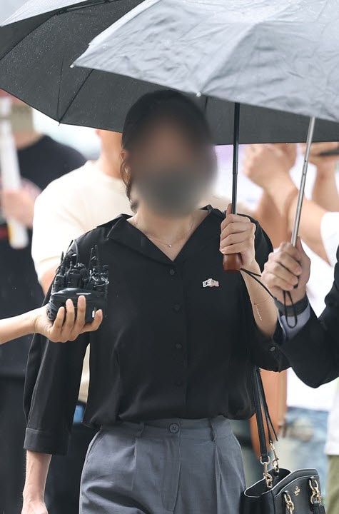 6·3 지방선거 개표소로 사용된 올림픽공원 핸드볼경기장 문 앞에서 체육단체 직원들의 장내 사무실 진입을 막아 업무 방해 혐의를 받는 30대 여성이 21일 구속 전 피의자 심문(영장실질심사)을 위해 서울 송파구 서울동부지법으로 출석하고 있다.(사진=연합뉴스)