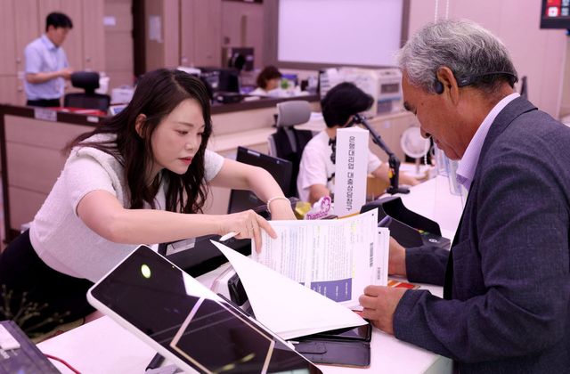 우정사업본부가 지난 20일 은행대리업 시범운영을 시작한 가운데, 충북 청양우체국 소속 한 직원이 고객에게 시중은행 대출 신청을 한 고객에게 안내를 하고 있다.(사진=우정사업본부)