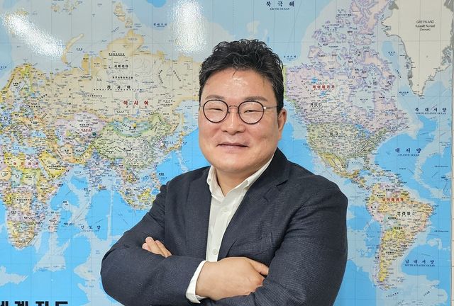 세계지도 앞에서 포즈를 취한 진영호 BGF리테일 상품·해외사업부문장 (사진=한전진 기자)