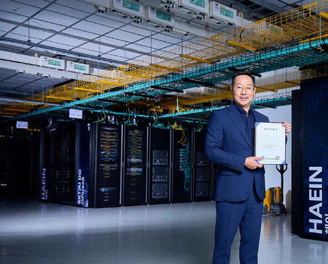 해인 클러스터 앞에서 김명국 SKT AI Factory 사업담당이 CSAP 인증서를 들고 포즈를 취하는 모습. 사진=SK텔레콤