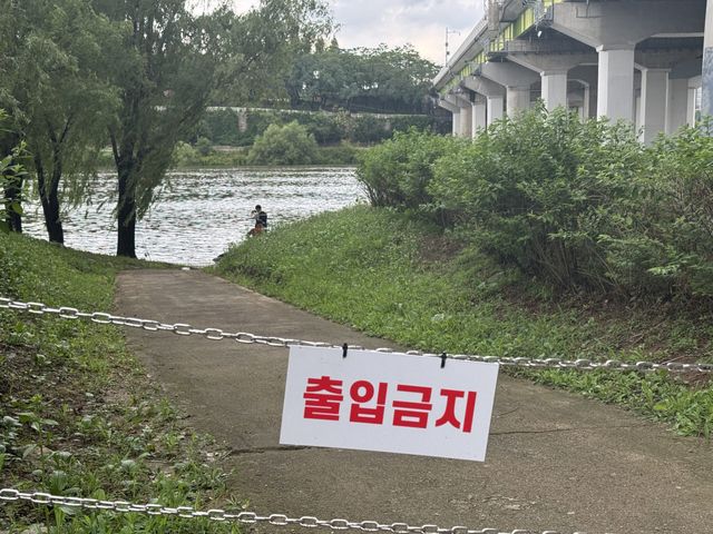 서울에 첫 호우경보가 내려진 9일, 서울 양화한강공원에서 한 시민이 낚시를 하고 있다. 입구엔 '출입금지' 표지가 걸려있다. (사진= 강민혁 수습기자)